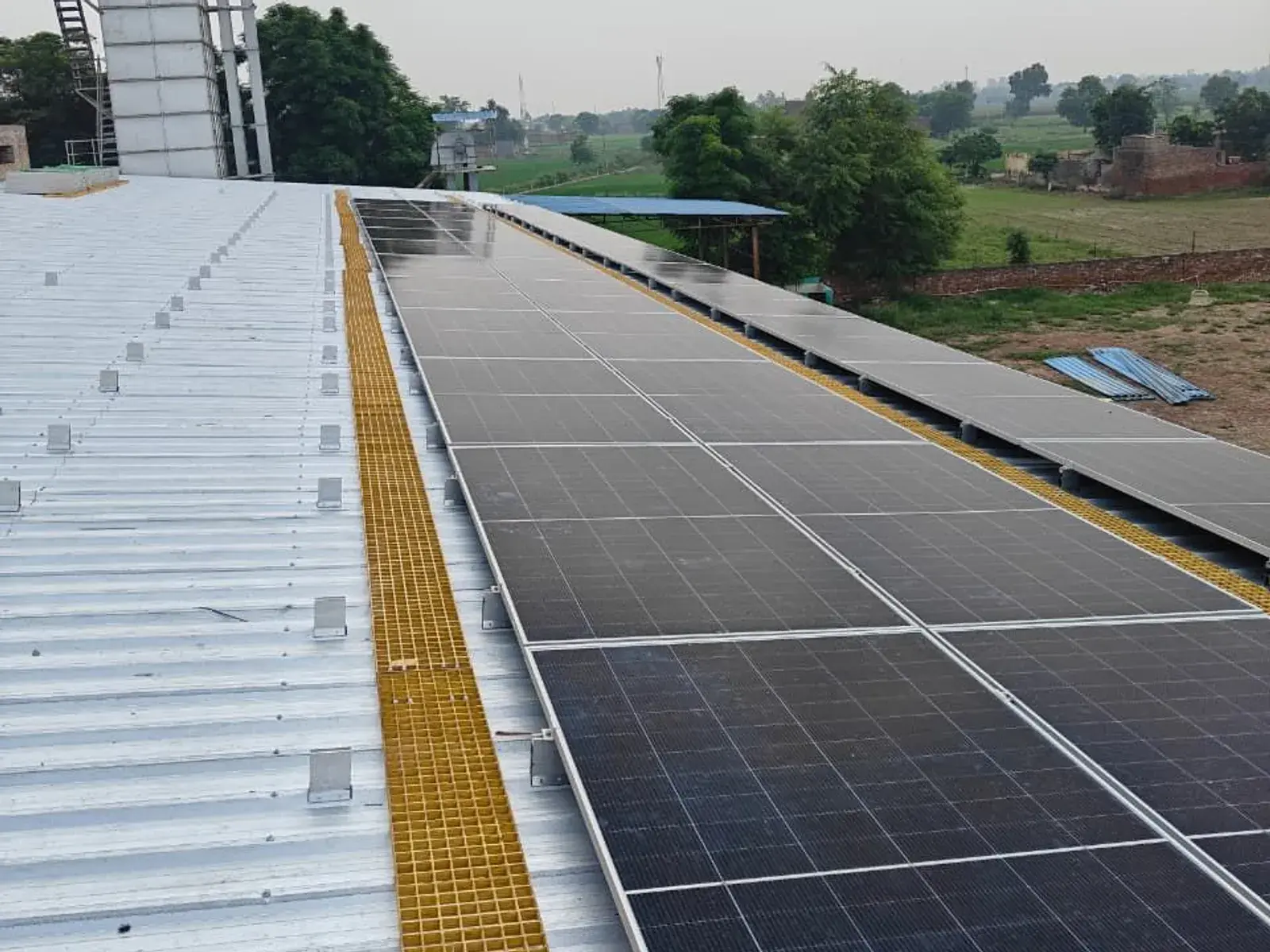Completed solar array beside the walkway with the paddy dryer in the background